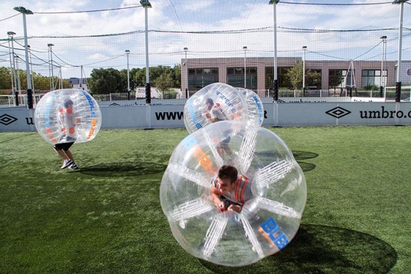 quatre personnesse préparent pour commencer le match de bubble foot sur un terrain extérieur