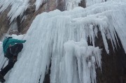 un homme escalade une cascade de glace